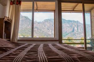 a bedroom with a large bed with a mountain view at Posada Paraiso in Tepoztlán
