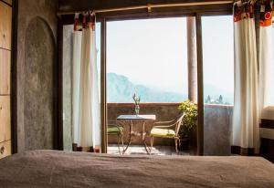Posada Paraiso في تيبوزتلان: غرفة نوم بسرير وطاولة وكراسي