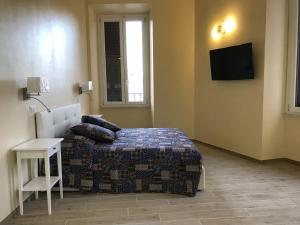 ローマにあるServenti Longhi Roomsのベッドルーム1室(ベッド1台、壁掛けテレビ付)