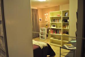セルモネータにあるMini Loft Ninfa Casa Vacanzaのベッドルーム(ベッド1台、本棚付)