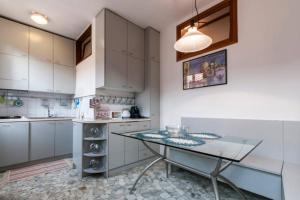 a kitchen with white cabinets and a glass table at KEY LOCATION near Palazzo Grassi in Venice