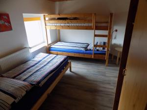 a bedroom with two bunk beds and a window at Leuchtturm in Friederikensiel
