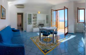 a living room with a table and blue chairs at Sirenetta in Amalfi