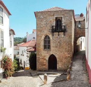 オビドスにあるCasa de férias Josefa D´Óbidosの古いレンガ造りの建物(ドア、バルコニー付)