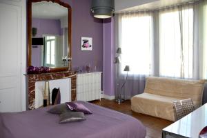 - une chambre avec un lit, un miroir et un canapé dans l'établissement Chambres d'hôtes L'Escale Malouine, à Dunkerque