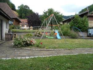 a playground in a yard with a girl on a swing at LA MAISON EN PAIN D'EPICES in Sainte-Marie-aux-Mines