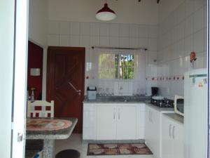 eine Küche mit weißen Schränken und einer braunen Tür in der Unterkunft Pousada Estrela Guia in Florianópolis