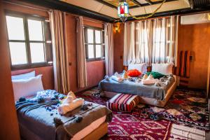 a bedroom with two beds and a couch and windows at Toubkal Ecolodge in Imlil