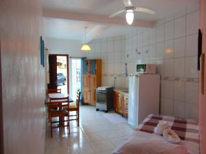 uma cozinha com uma cama, uma mesa e um frigorífico em Pousada Estrela Guia em Florianópolis