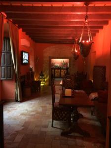 une salle à manger avec des murs rouges, une table et des chaises dans l'établissement Hacienda Los Jinetes, à Carmona