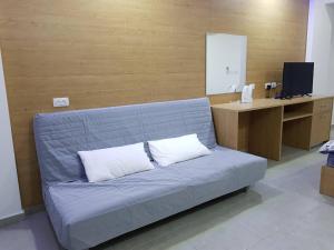 a blue couch with two white pillows in a room at סנו נופש בגולן in Majdal Shams