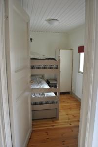 a bedroom with a bunk bed and a wooden floor at Sandgårdsborg in Färjestaden
