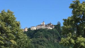 a castle on top of a hill with trees at RIVER resort in Varallo