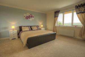 a bedroom with a large bed and a window at Lochview Chalet in Eyre