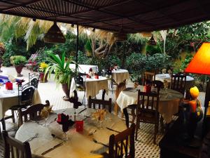 a restaurant with tables and chairs in a courtyard at Maison Couleur Passion in Nianing