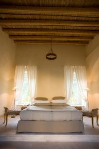 um quarto com uma cama grande e 2 janelas em Castello Camemi em Vizzini