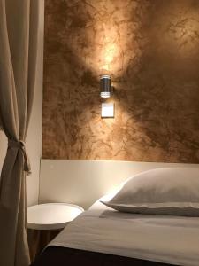 a bedroom with a bed with a light on the wall at Secret Garden Apartment in Zadar