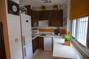セビリアにあるMarqués de San Lorenzo -2 dormitorios & FREE parkingのキッチン(白い冷蔵庫、木製キャビネット付)