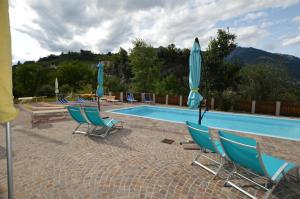 a swimming pool with chairs and umbrellas next to at Vermietung Obermais in Merano