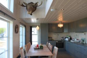 uma cozinha com uma mesa com uma cabeça de veado pendurada no tecto em Luxury Mountain Villa em Strandlykkja