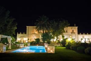 a large house with a swimming pool at night at Castello Camemi in Vizzini
