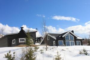 uma casa negra com neve no chão em Luxury Mountain Villa em Strandlykkja