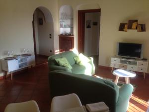 ナポリにあるAppartamento Vittoriaのリビングルーム(緑のソファ、テレビ付)