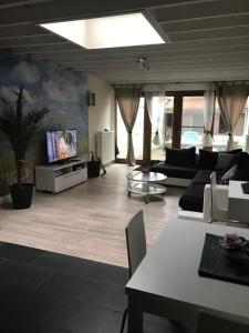 ein Wohnzimmer mit einem Sofa und einem TV in der Unterkunft Just Relax in Ostende