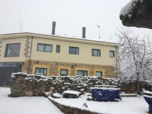 a house covered in snow in front at Casa la Devesa de Sanabria in Remesal