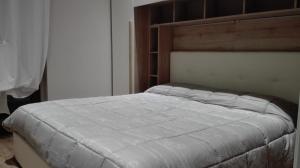 ポルト・サンテルピーディオにあるAppartamento Vittoriaのベッドルーム1室(木製ヘッドボード付)