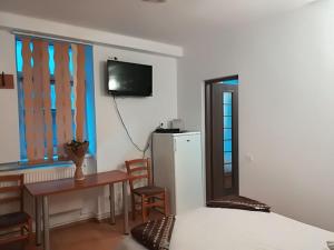 a bedroom with a bed and a table and a television at Center Park Apartment in Cluj-Napoca