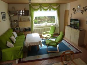 a living room with green furniture and a window at Ferienhaus "Finkennest" in Berumbur