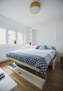 ザグレブにあるSweet & Petiteの白いベッドルーム(青い毛布付きのベッド付)