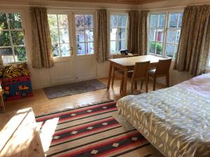 a bedroom with a bed and a table and chairs at Crabapple Cottage B&B in Lewes