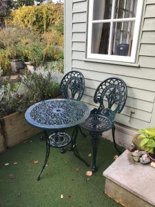 una mesa y dos sillas sentadas junto a una casa en Crabapple Cottage B&B en Lewes