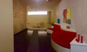 una camera con divano rosso in una stanza con di apartamento de 2 quartos, PRAIA DE ICARAI NITEROI a Niterói