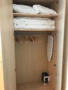 un placard avec des étagères en bois et des serviettes blanches dans l'établissement Appartement Chamrousse le Vernon, à Chamrousse