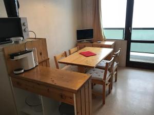 Cette chambre dispose d'une table en bois et d'un bureau avec un ordinateur. dans l'établissement Appartement Chamrousse le Vernon, à Chamrousse
