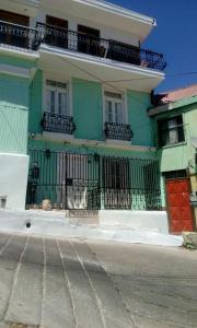 un edificio verde y blanco con una puerta roja en Casa Mackenna, en Valparaíso