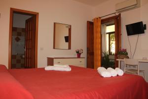 Un dormitorio con una cama roja con dos toallas. en Fiori e Limoni, en Quartucciu 59 fotos más
