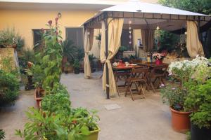 a patio with an umbrella and tables and plants at Fiori e Limoni in Quartucciu