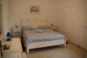 ein Schlafzimmer mit einem weißen Bett und zwei Nachttischen in der Unterkunft Villa Gabriela in Rogón