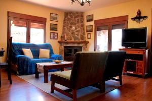 Una sala de estar con un sofá azul y un televisor. en Casa Rural Nacimiento Rio Mundo, en Riópar