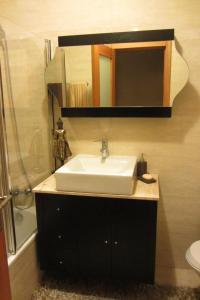 une salle de bain avec un lavabo et un miroir dans l'établissement Apartamento Superior Helena's Porto Corner, à Vila Nova de Gaia 34 autres photos