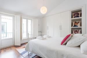リスボンにあるExplore Vibrant Lisbon from a Designer Loft at Casa da Barrocaの白いベッドルーム(大きな白いベッド1台、窓付)