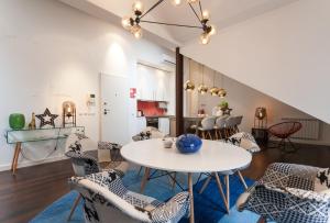 ein Wohnzimmer mit einem Tisch und Stühlen in der Unterkunft Explore Vibrant Lisbon from a Designer Loft at Casa da Barroca in Lissabon