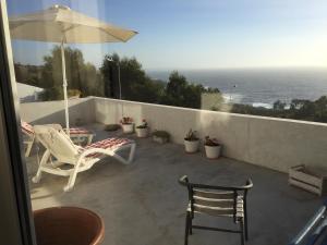 a patio with a table and chairs and an umbrella at Alojamiento Independiente in Zapallar