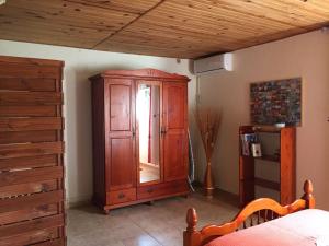 a bedroom with a wooden cabinet and a bed at Chez Momo et Dany in Deshaies