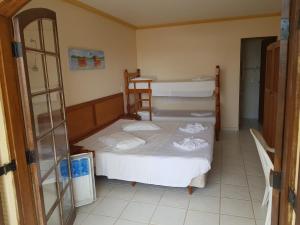 a bedroom with two bunk beds and a table at Pousada Recanto do Morro in Cananéia