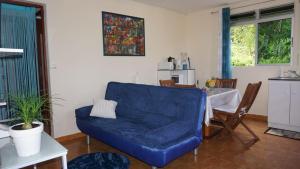 a living room with a blue couch and a table at Chez Momo et Dany in Deshaies